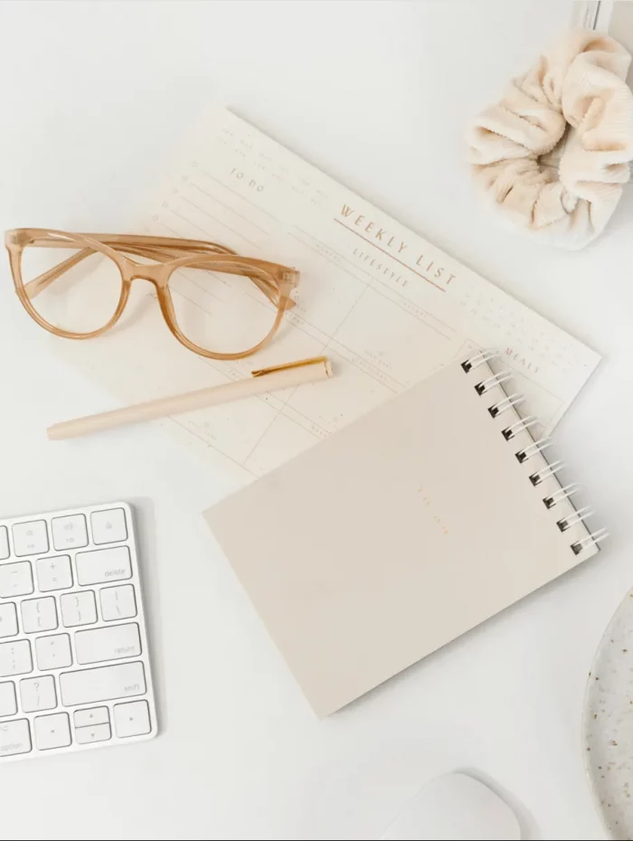 Notizbuch und Brille auf hellem Schreibtisch – Symbol für Fokus, Lernen und achtsames Arbeiten